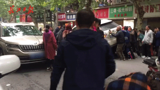 武汉街头砰一声响，女子大喊救命！30多人将一辆越野车抬了起来！